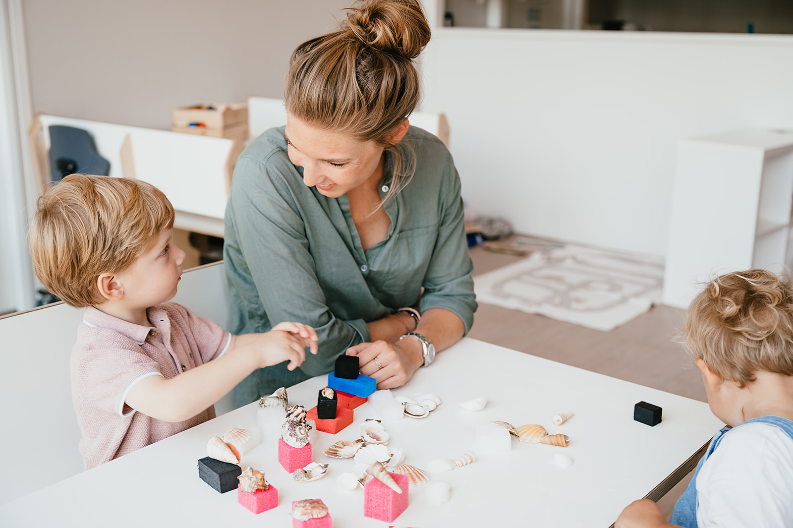 Werken bij CompaNanny Pedagogisch Medewerker en kind spelen met schelpen